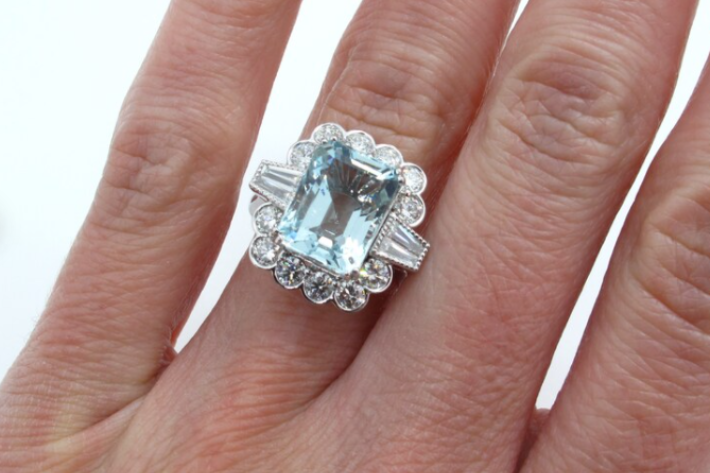 Aquamarine ring with diamond halo on hand